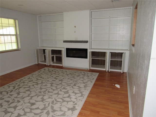 1440 Hackl Blvd, Bartow, FL 33830 - unfurnished living room with wood finished floors, a glass covered fireplace, and built in features