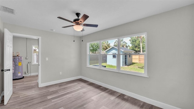 980 S Mill Ave, Bartow, FL 33830 - spare room with water heater, light wood-style floors, and a ceiling fan
