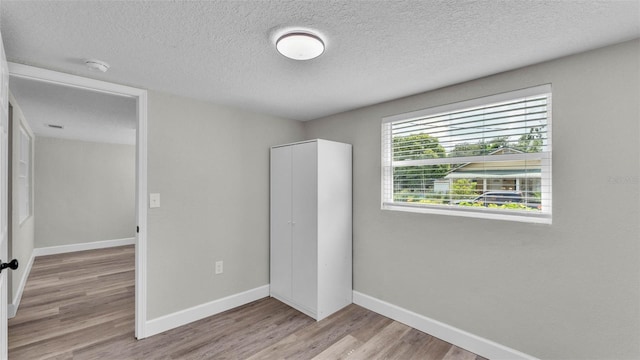 980 S Mill Ave, Bartow, FL 33830 - unfurnished bedroom featuring light wood finished floors, a textured ceiling, and a closet