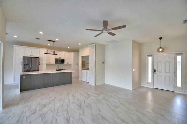4188 Muirfield Loop, Lake Wales, FL 33859 - kitchen featuring appliances with stainless steel finishes, independent washer and dryer, light countertops, open floor plan, and recessed lighting
