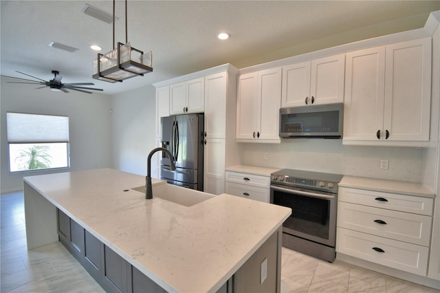4188 Muirfield Loop, Lake Wales, FL 33859 - kitchen featuring stainless steel appliances, white cabinetry, ceiling fan, recessed lighting, and a center island with sink