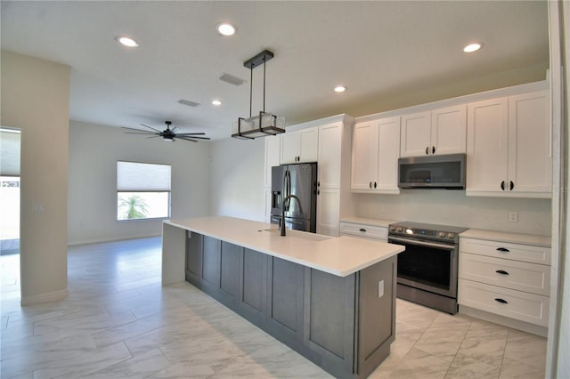 4188 Muirfield Loop, Lake Wales, FL 33859 - kitchen with appliances with stainless steel finishes, light marble finish floors, a kitchen island with sink, white cabinets, and light countertops
