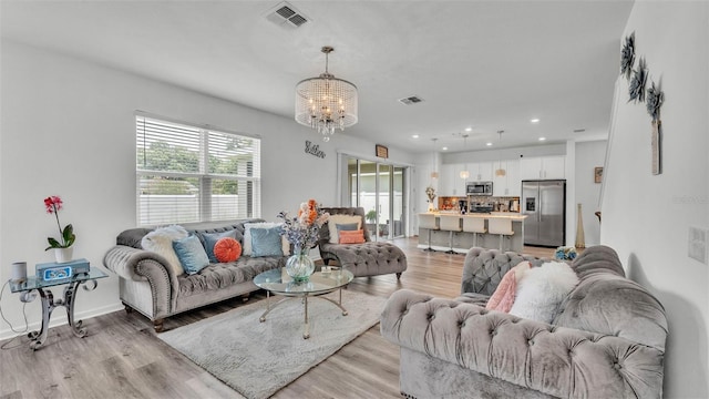 1125 Mattie Pointe Blvd, Auburndale, FL 33823 - living room featuring a chandelier, light wood-style floors, and recessed lighting