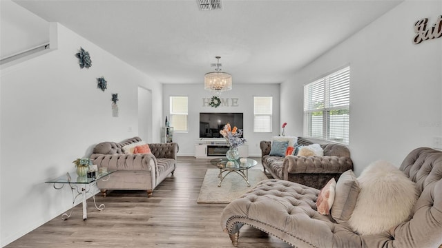 1125 Mattie Pointe Blvd, Auburndale, FL 33823 - living room featuring plenty of natural light, wood finished floors, and a chandelier