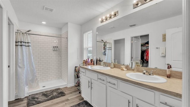 1125 Mattie Pointe Blvd, Auburndale, FL 33823 - bathroom featuring a shower stall, double vanity, a spacious closet, wood finished floors, and recessed lighting