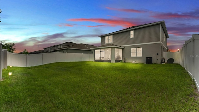 1125 Mattie Pointe Blvd, Auburndale, FL 33823 - back of property at dusk featuring a sunroom, a fenced backyard, and stucco siding