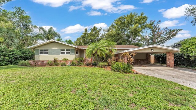 4219 Forest Hills Dr, Lakeland, FL 33813 - ranch-style house featuring concrete driveway, a front yard, an attached carport, and brick siding