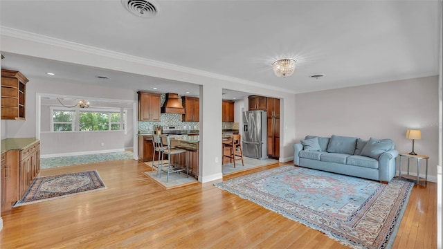4219 Forest Hills Dr, Lakeland, FL 33813 - living area with a chandelier, light wood finished floors, and ornamental molding