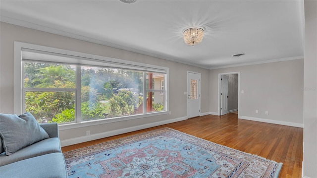 4219 Forest Hills Dr, Lakeland, FL 33813 - living room with healthy amount of natural light, ornamental molding, wood finished floors, and a chandelier