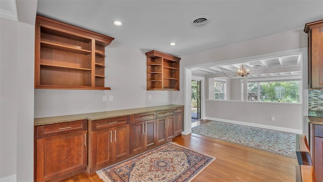 4219 Forest Hills Dr, Lakeland, FL 33813 - kitchen featuring open shelves, light wood-type flooring, a chandelier, recessed lighting, and light stone counters
