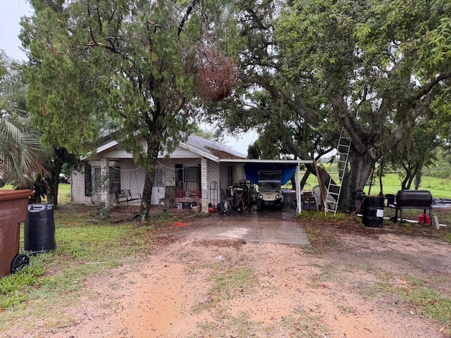4011 E Robinson Dr, Haines City, FL 33844 - single story home with brick siding, dirt driveway, an attached carport, and covered porch