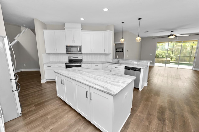 228 Magneta Loop, Auburndale, FL 33823 - kitchen featuring stainless steel appliances, a peninsula, a center island, ceiling fan, and tasteful backsplash