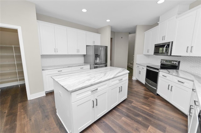 228 Magneta Loop, Auburndale, FL 33823 - kitchen with appliances with stainless steel finishes, a center island, decorative backsplash, dark wood-type flooring, and recessed lighting