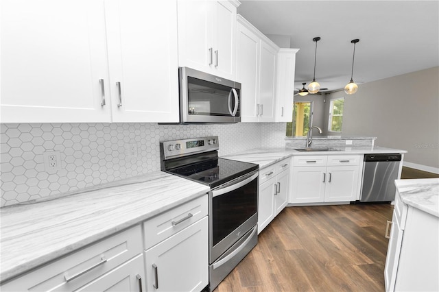 228 Magneta Loop, Auburndale, FL 33823 - kitchen featuring stainless steel appliances, dark wood-style flooring, white cabinetry, backsplash, and a peninsula