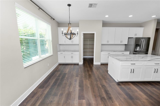 228 Magneta Loop, Auburndale, FL 33823 - kitchen with stainless steel fridge with ice dispenser, a chandelier, backsplash, white cabinetry, and decorative light fixtures