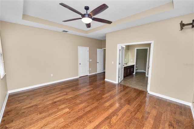 228 Magneta Loop, Auburndale, FL 33823 - empty room featuring a raised ceiling, dark wood-type flooring, and ceiling fan