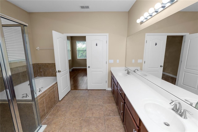 228 Magneta Loop, Auburndale, FL 33823 - bathroom featuring double vanity, a garden tub, a shower stall, and tile patterned floors