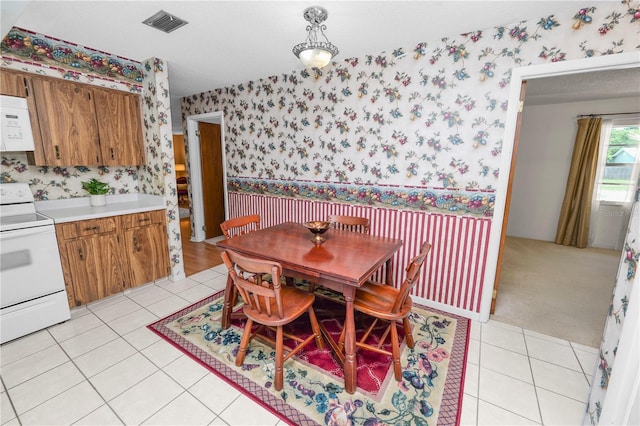 3315 Cross Fox Dr, Mulberry, FL 33860 - dining space featuring wallpapered walls, wainscoting, and light tile patterned floors