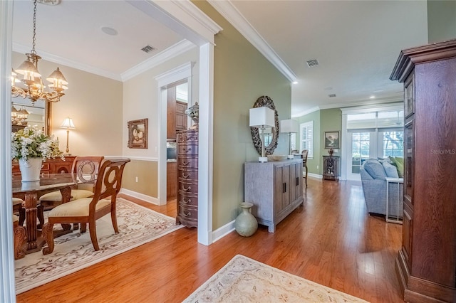 1589 Royal Forest Ct, Lakeland, FL 33811 - hallway featuring light wood finished floors, crown molding, and a chandelier