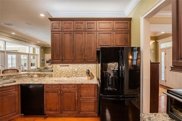 1589 Royal Forest Ct, Lakeland, FL 33811 - kitchen with black appliances, ornamental molding, light stone countertops, and light wood finished floors