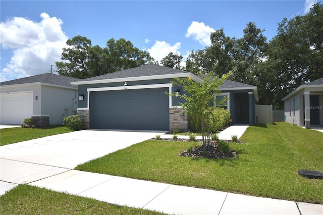 312 Walnut Ln, Auburndale, FL 33823 - view of front of house featuring a front lawn, a garage, concrete driveway, stone siding, and stucco siding