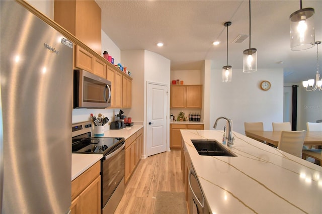312 Walnut Ln, Auburndale, FL 33823 - kitchen with stainless steel appliances, light wood-style flooring, pendant lighting, recessed lighting, and a textured ceiling