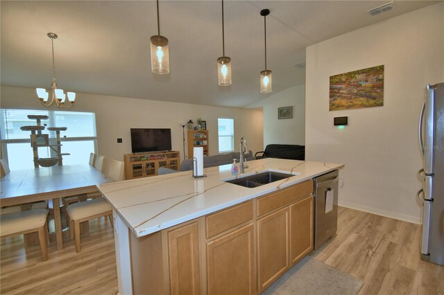 312 Walnut Ln, Auburndale, FL 33823 - kitchen with stainless steel appliances, light wood-type flooring, vaulted ceiling, an island with sink, and hanging light fixtures