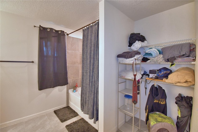 312 Walnut Ln, Auburndale, FL 33823 - full bathroom featuring a textured ceiling, shower / bathtub combination with curtain, and tile patterned floors