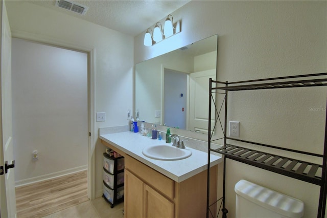 312 Walnut Ln, Auburndale, FL 33823 - bathroom with vanity, wood finished floors, a textured ceiling, and a textured wall