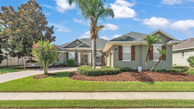 2817 High Winds Ln, Lakeland, FL 33813 - view of front of home with stucco siding, driveway, a shingled roof, and a front lawn