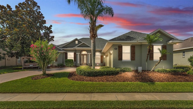 2817 High Winds Ln, Lakeland, FL 33813 - view of front of house with stucco siding, a shingled roof, driveway, and a front yard