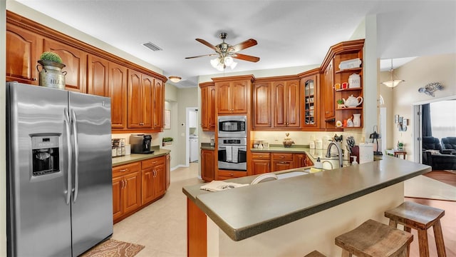 2817 High Winds Ln, Lakeland, FL 33813 - kitchen featuring appliances with stainless steel finishes, ceiling fan, a kitchen breakfast bar, and brown cabinets