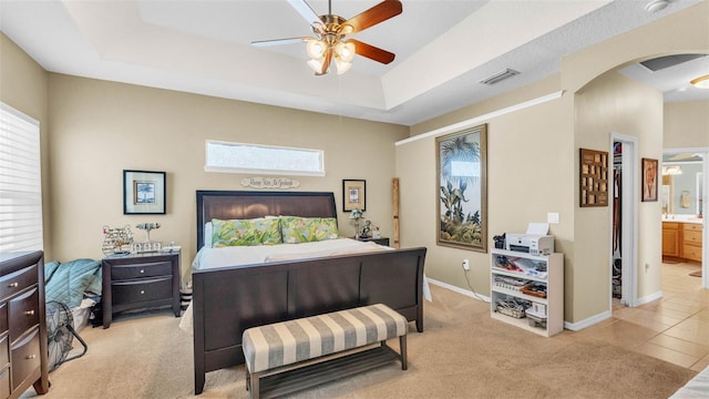 2817 High Winds Ln, Lakeland, FL 33813 - bedroom featuring arched walkways, multiple windows, a raised ceiling, and light colored carpet
