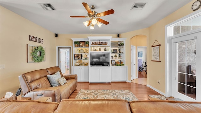 2817 High Winds Ln, Lakeland, FL 33813 - living area with arched walkways, a ceiling fan, and light wood-type flooring