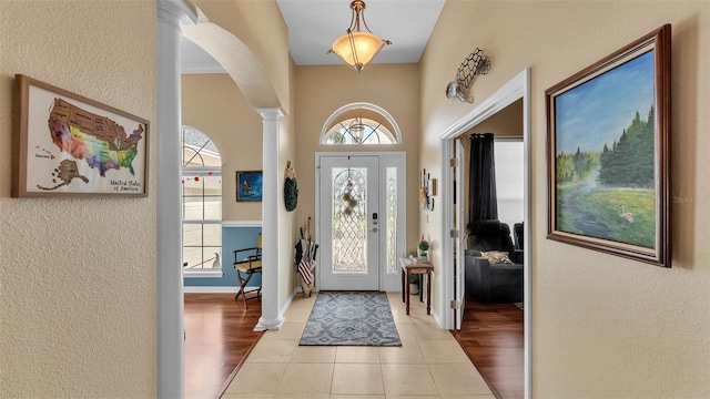 2817 High Winds Ln, Lakeland, FL 33813 - entrance foyer featuring ornate columns, arched walkways, a textured wall, and light tile patterned flooring