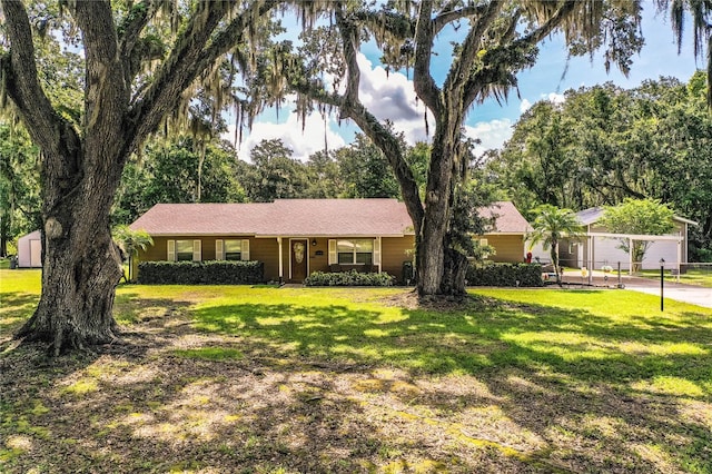 6920 Newman Cir E, Lakeland, FL 33811 - ranch-style home with a front lawn and a storage unit