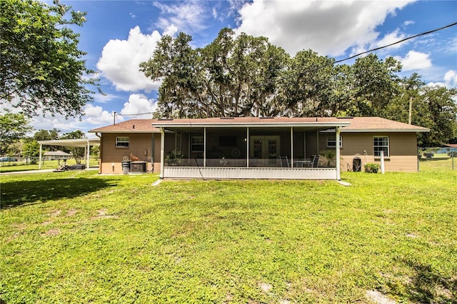 6920 Newman Cir E, Lakeland, FL 33811 - back of property featuring a sunroom, a lawn, and a carport