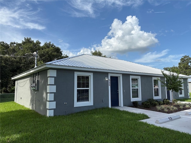 508 2nd St SW, Fort Meade, FL 33841 - view of front of property featuring stucco siding, a front lawn, and a metal roof