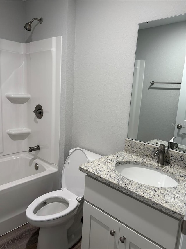 508 2nd St SW, Fort Meade, FL 33841 - bathroom featuring vanity, washtub / shower combination, wood finished floors, and a textured wall