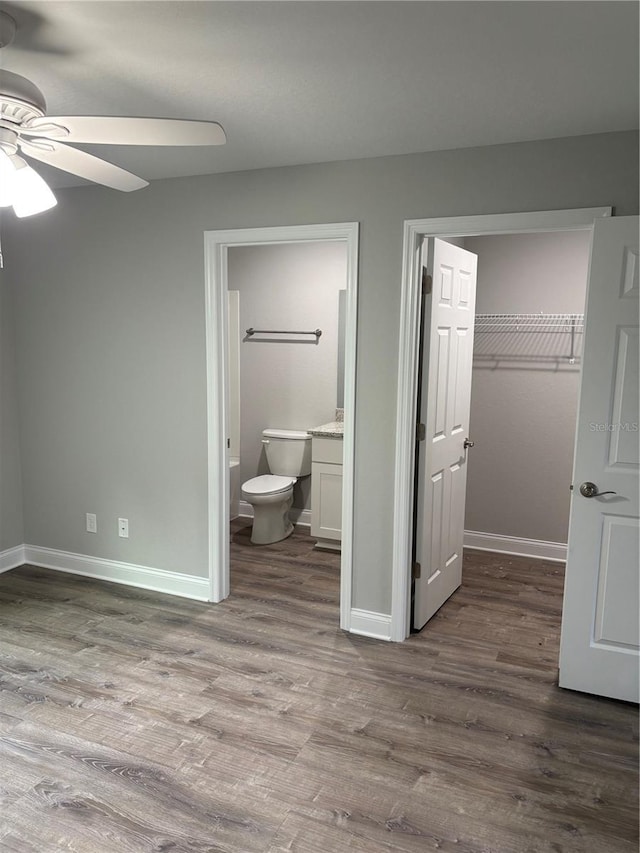 508 2nd St SW, Fort Meade, FL 33841 - unfurnished bedroom with a closet, dark wood-style flooring, a walk in closet, and ensuite bath