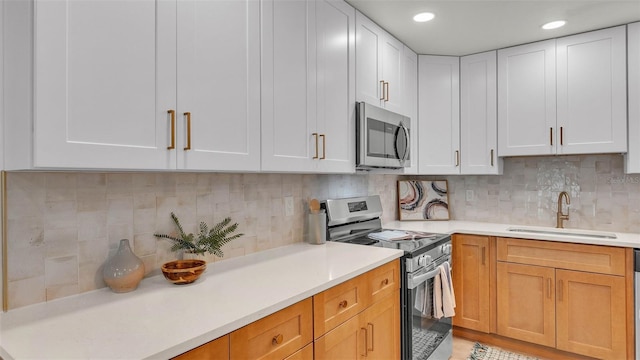 3235 Sandpiper Ln, Mulberry, FL 33860 - kitchen with appliances with stainless steel finishes, light countertops, decorative backsplash, white cabinetry, and recessed lighting
