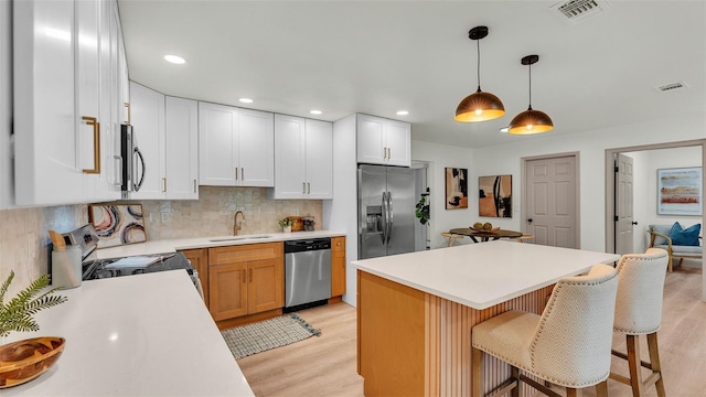 3235 Sandpiper Ln, Mulberry, FL 33860 - kitchen with appliances with stainless steel finishes, light wood-style floors, light countertops, a breakfast bar area, and tasteful backsplash
