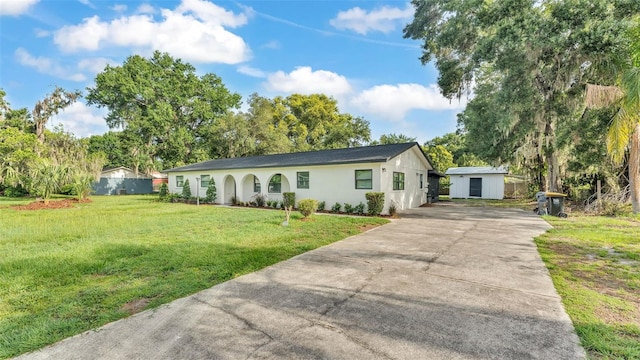 3235 Sandpiper Ln, Mulberry, FL 33860 - ranch-style home featuring driveway, a front yard, a storage unit, and stucco siding