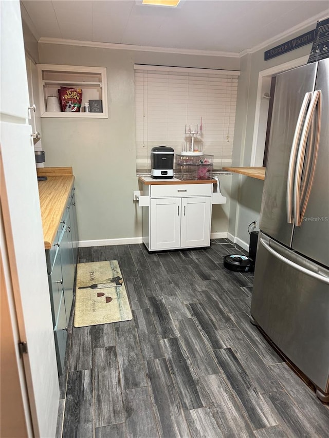 4818 Huron St, Zephyrhills, FL 33541 - kitchen with freestanding refrigerator, crown molding, butcher block counters, white cabinetry, and dark wood finished floors