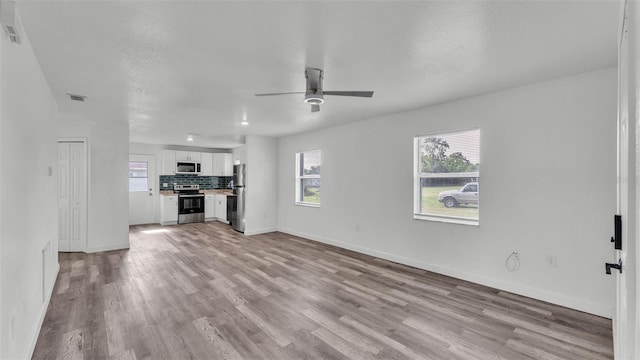 1050 Reynolds Rd, Lakeland, FL 33801 - unfurnished living room with light wood-style floors and a ceiling fan