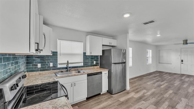 1050 Reynolds Rd, Lakeland, FL 33801 - kitchen with stainless steel appliances, white cabinets, decorative backsplash, and recessed lighting