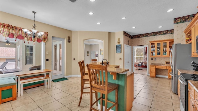 6757 High Grove Dr, Lakeland, FL 33813 - kitchen with range with electric cooktop, arched walkways, light tile patterned floors, wallpapered walls, and recessed lighting