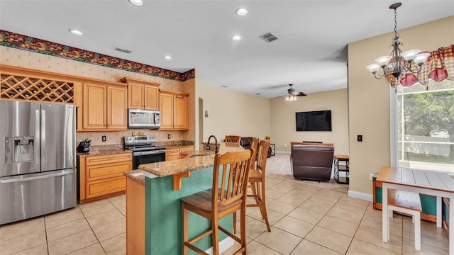 6757 High Grove Dr, Lakeland, FL 33813 - kitchen featuring appliances with stainless steel finishes, a ceiling fan, light tile patterned flooring, a breakfast bar, and open floor plan