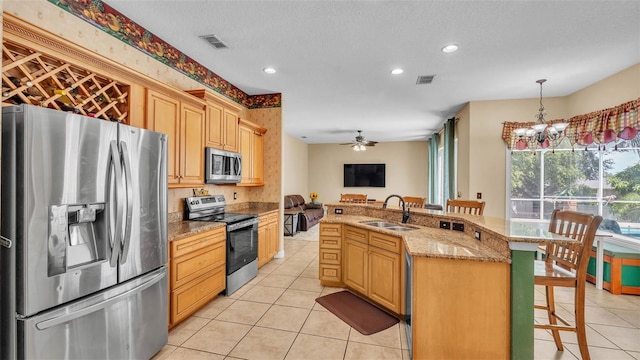 6757 High Grove Dr, Lakeland, FL 33813 - kitchen featuring appliances with stainless steel finishes, light tile patterned floors, a breakfast bar area, recessed lighting, and light stone countertops