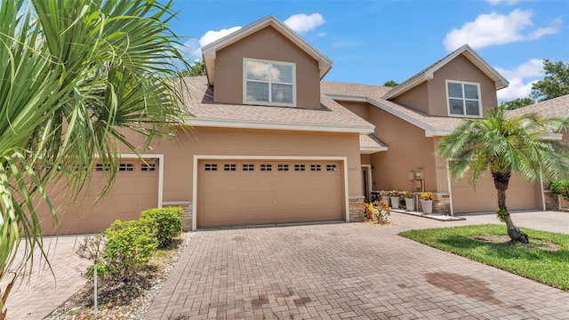 6365 Torrington Cir, Lakeland, FL 33811 - view of front of house featuring stucco siding, stone siding, decorative driveway, and roof with shingles